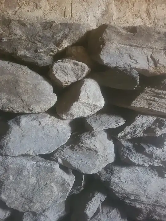 another section where I don't see any mortar, only right at the top where the stone meets the brick. there isn't really any dirt in this section as an addition was put on and the opposite side is now inside, no ground behind it.