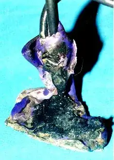 woman's hand next to a second capped off metal pipe