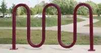 single metal tube bent into multiple loops for bicycle to be supported perpendicular to the longest direction of the bicycle stand, similar to wall_loops